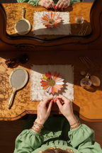 stained glass colorful flower ring holder on vintage vanity with mirror reflection and hands, elegant jewelry tray