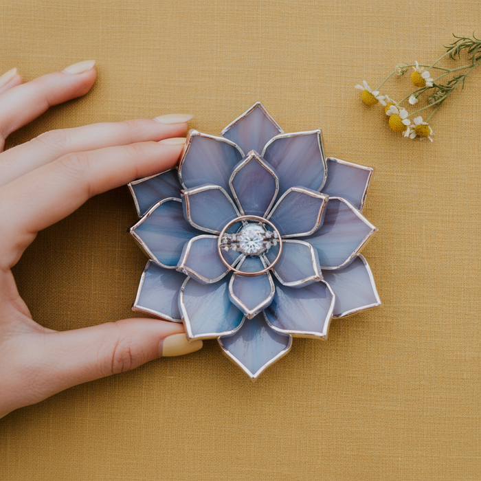 Floral ring holder with a diamond ring on a yellow fabric background