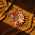 Sunburst shaped stained glass jewelry tray on a brown velvet surface